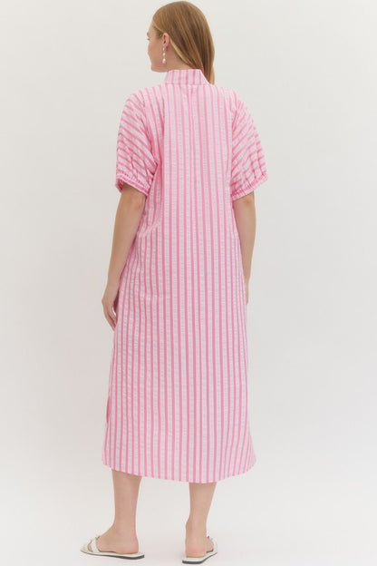 Woman wearing a pink and white striped dress on a white background