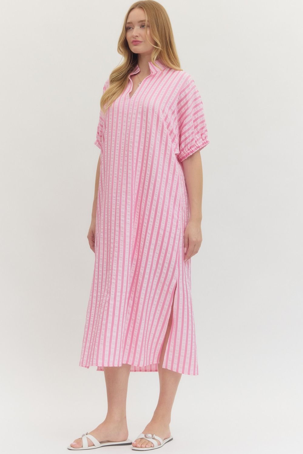 Woman wearing a pink and white striped dress on a white background