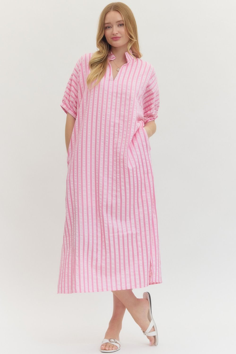 Woman wearing a pink and white striped dress on a white background