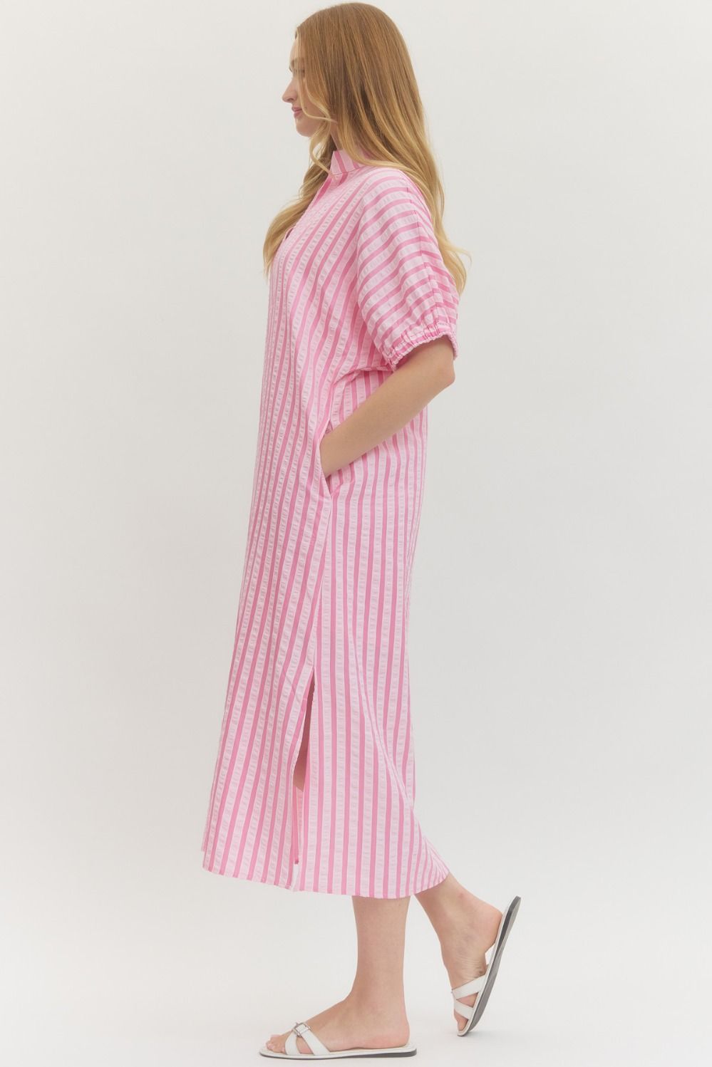 Woman wearing a pink and white striped dress on a white background