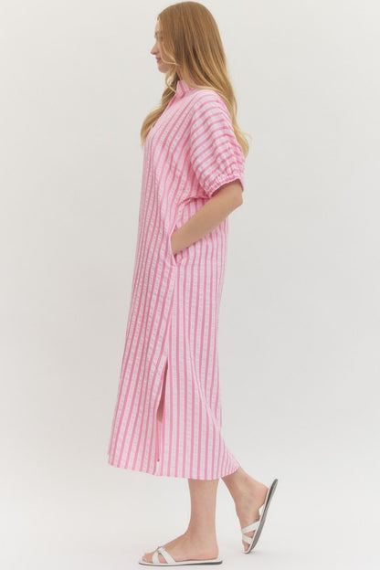 Woman wearing a pink and white striped dress on a white background