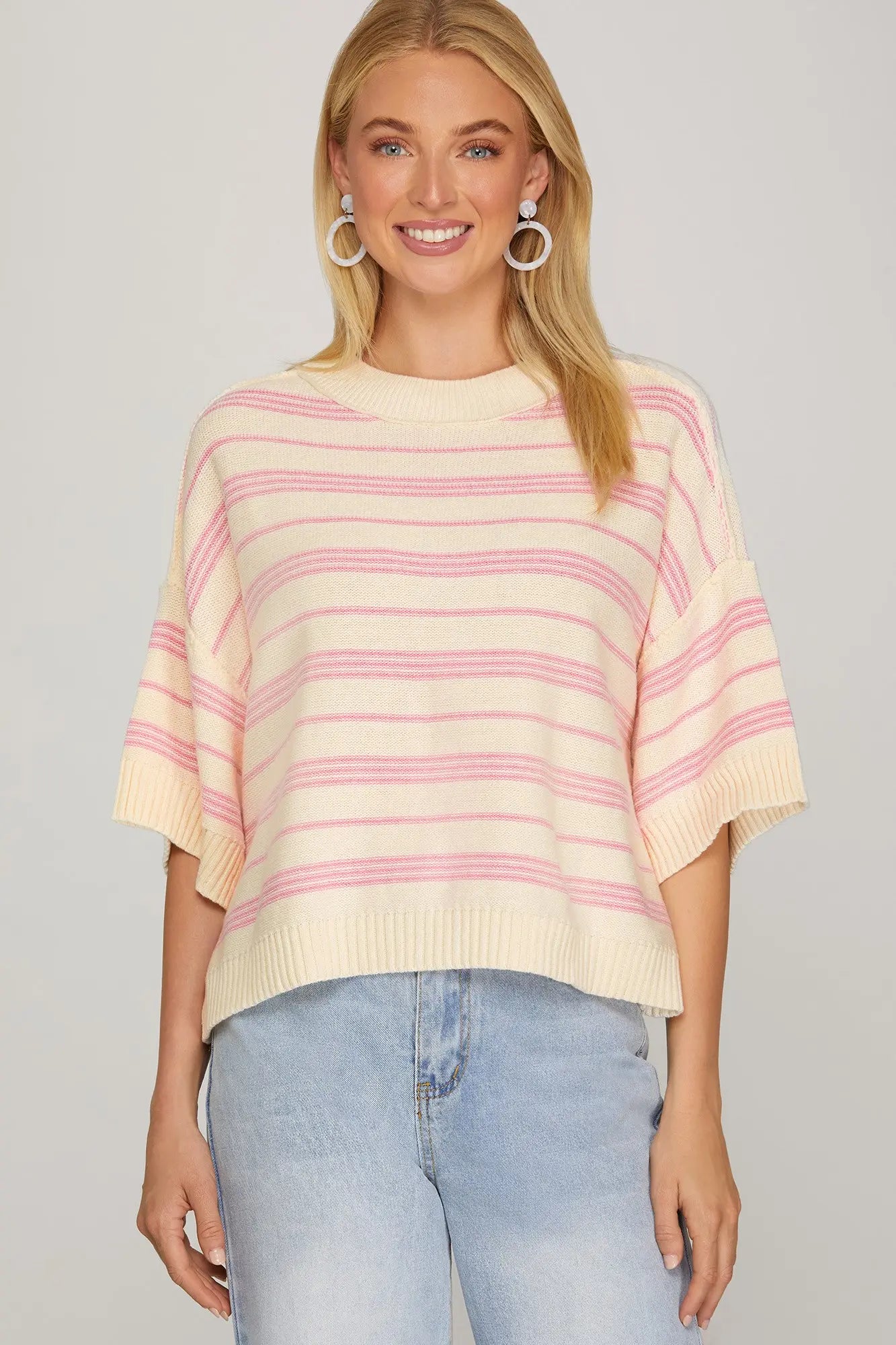 Model wearing cream and pink striped short sleeve knit sweater—front view.
