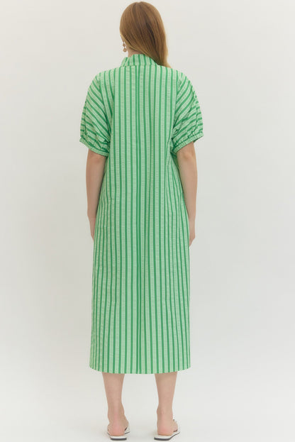Green and white striped dress worn by a person on a white background
