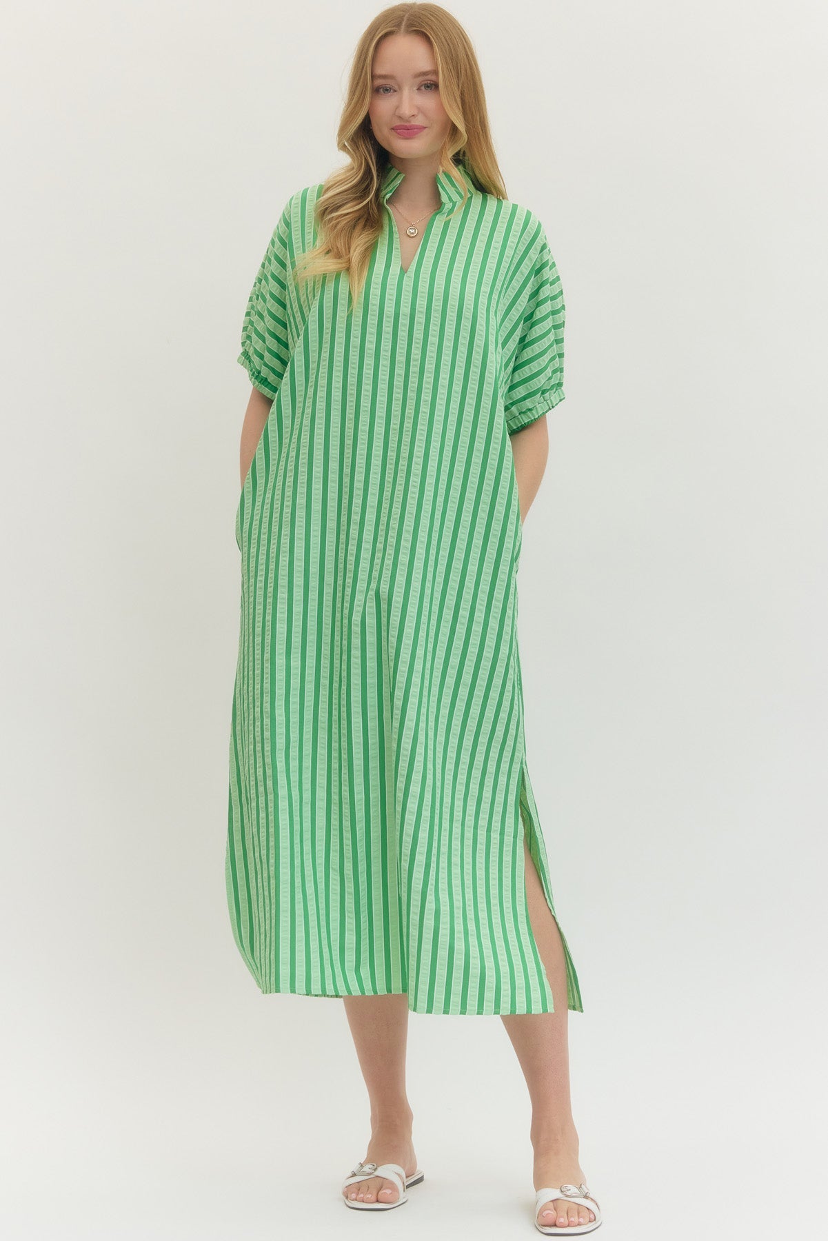 Woman wearing a green and white striped dress on a white background
