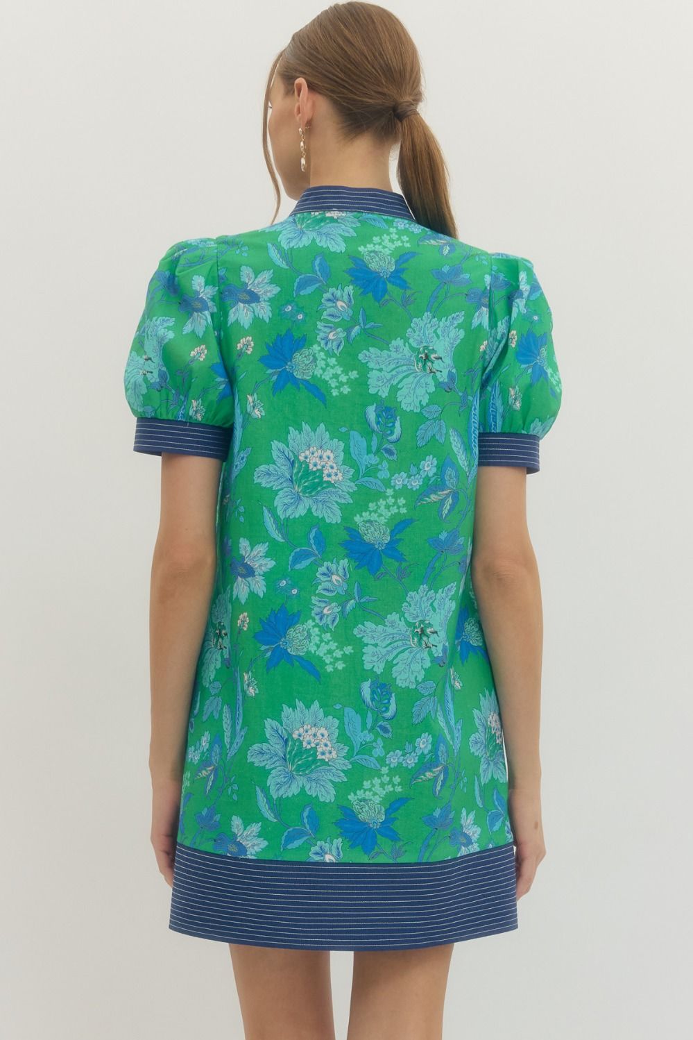 Green floral dress with blue accents on a plain background