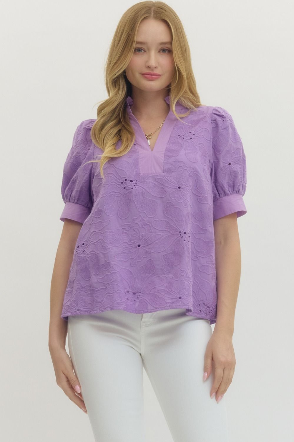 Woman wearing a purple blouse with puff sleeves on a white background