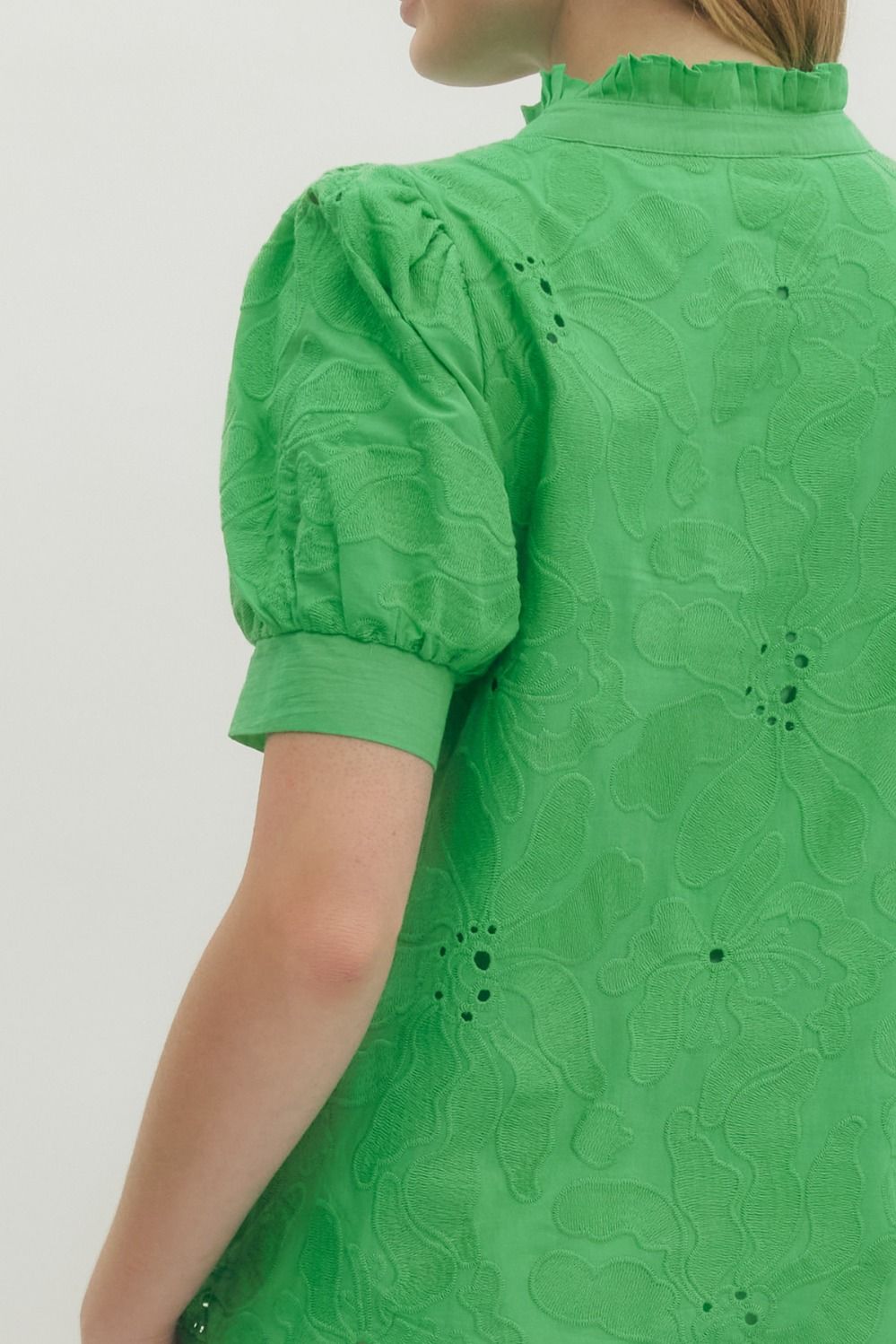 Green dress with floral pattern on a plain background
