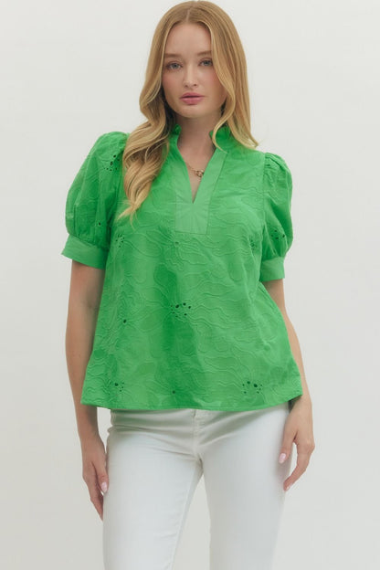Woman wearing a green blouse with puff sleeves on a white background
