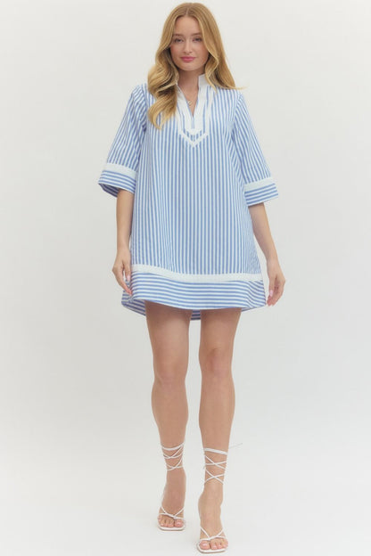 Woman wearing a blue and white striped dress on a white background