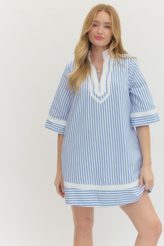 Woman wearing a blue and white striped dress on a plain background