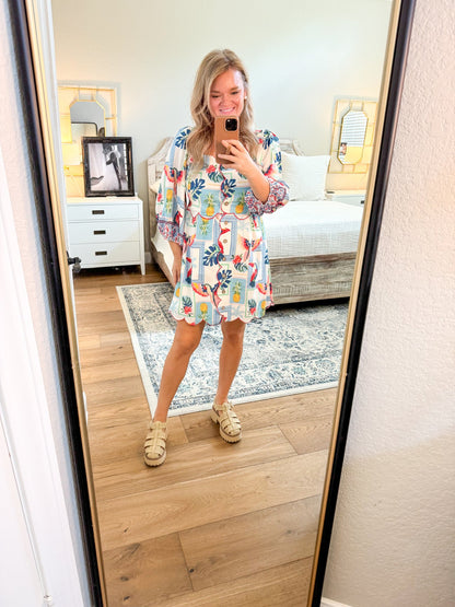 Woman taking a mirror selfie wearing a floral dress in a bedroom.