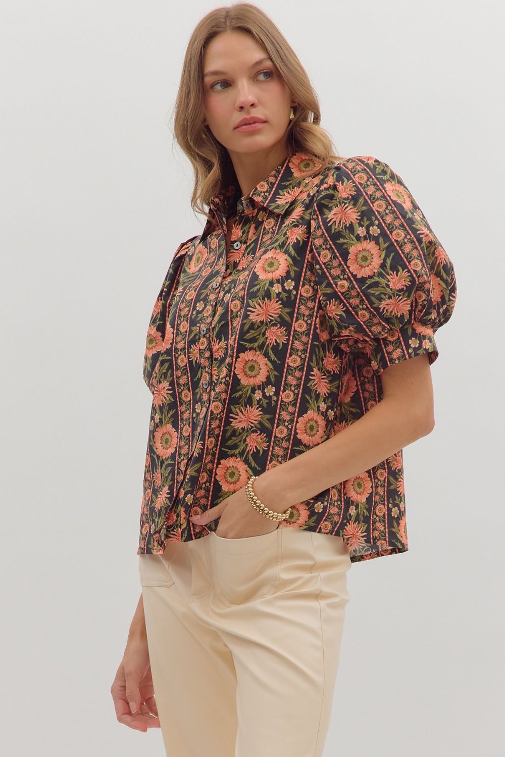 Side view of black floral button-up puff sleeve blouse with vintage-inspired print — chic boutique top.