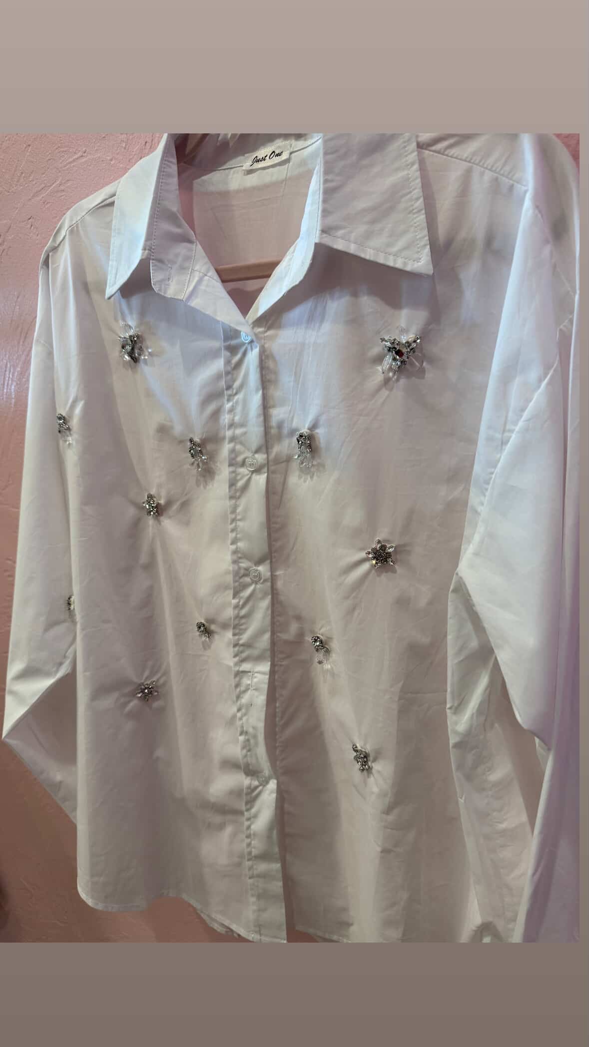 Side view of white crystal-embellished blouse with jeweled detailing, lightweight fabric, and classic collar at Milo & Lily Boutique.